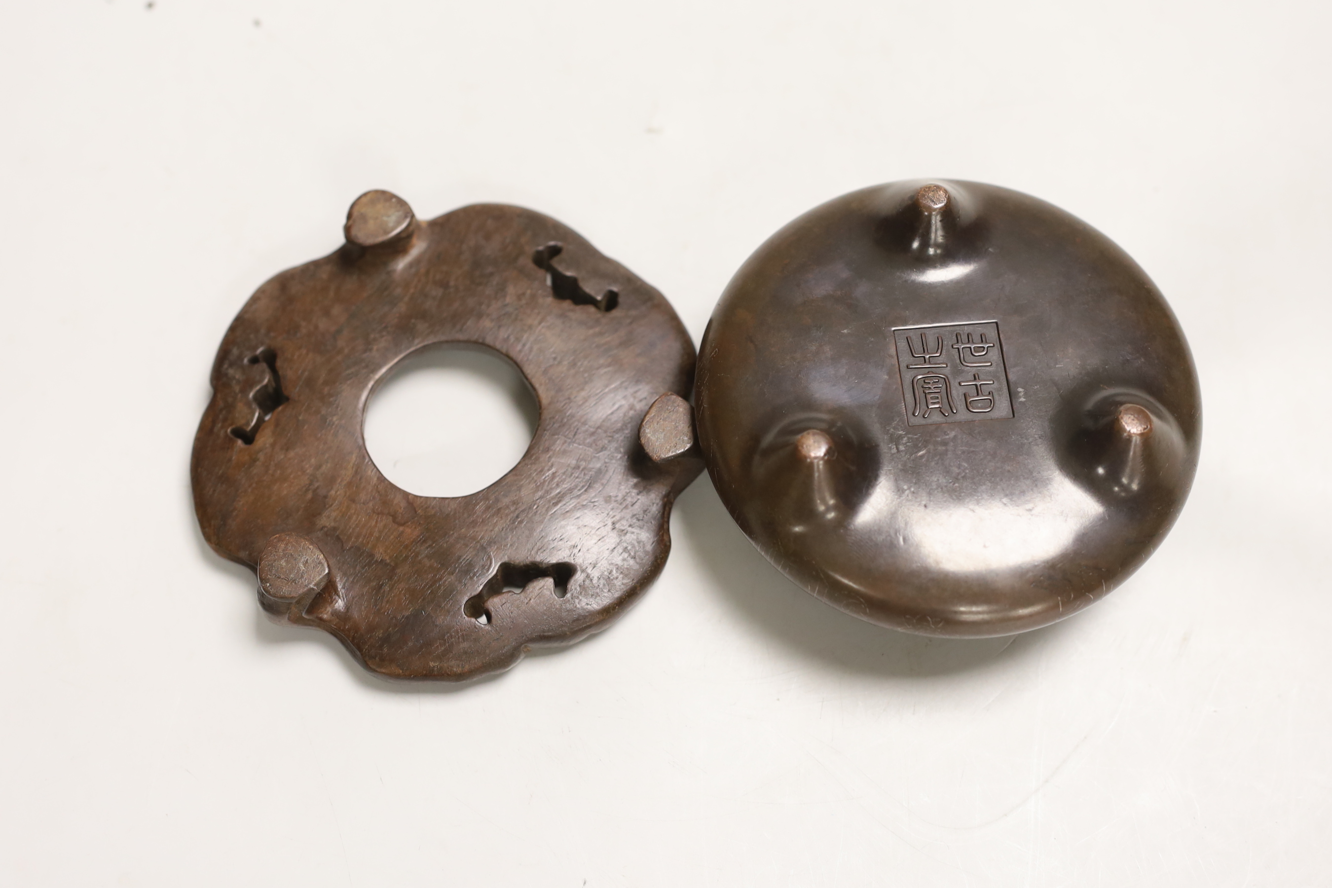 A Chinese bronze censer, on hardwood stand, 12.5cm diameter